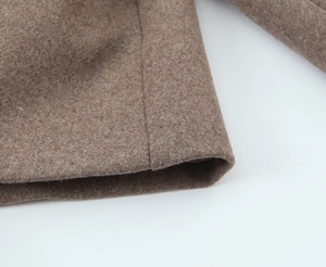 Detail shot of brown wool blend coat showing high-quality stitching and fabric texture