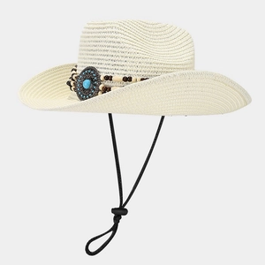 Detail of cream straw cowboy hat featuring ethnic beads and a turquoise metal accent