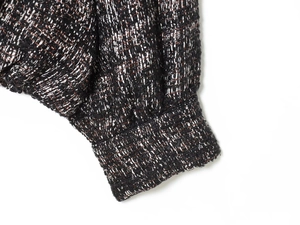 Close-up of tweed bomber jacket cuff with black, white, and copper metallic threads
