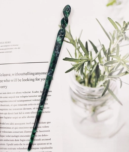 Close-up of a marble texture acetate hair pin with spiral top on a fashion magazine