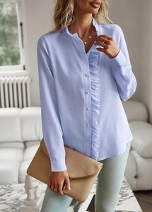 Détail de chemise à rayures bleu clair avec volants et pochette enveloppe de couleur beige