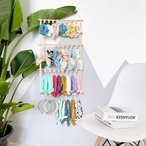 Wall-mounted wooden hair accessory organizer with colorful scrunchies and bows in a modern room