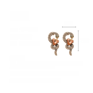 Detail shot of vintage snake earrings with heart-shaped orange gems and rhinestones