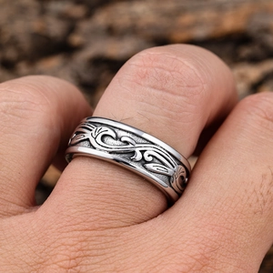 Macro detail of retro solid stainless steel ring with embossed vine pattern texture