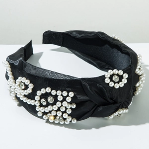Detailed view of black knot headband with faux pearl flower clusters and crystals