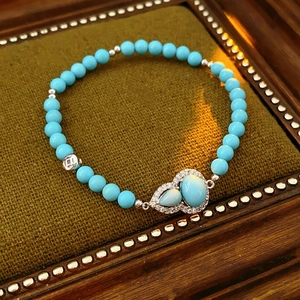 Detailed close-up of a turquoise gourd pendant bracelet with sparkling zircon accents