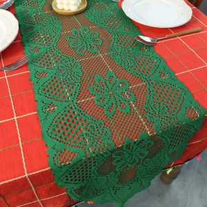 Green lace table runner with knitted strawberry and floral motifs for festive dining decor