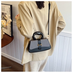 Detailed back view of a contrast-color box bag with arch handle and gold H-buckle