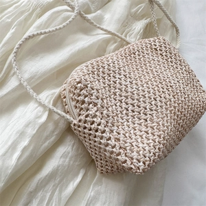 Handmade woven crossbody straw bag in beige for summer with a slim shoulder strap