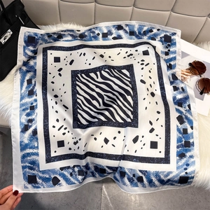 Elegant geometric print square silk scarf with zebra pattern and blue accents on soft fur
