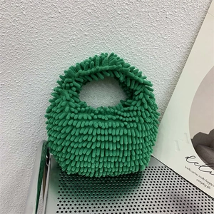 Detailed texture of a green plush chenille tote bag displayed on a stylish metal grid rack