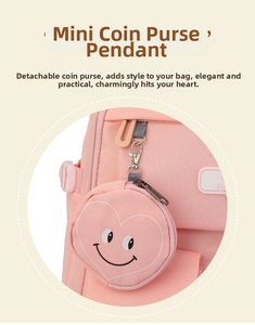 Pink heart smiley coin purse charm with metal clip on a matching canvas backpack detail