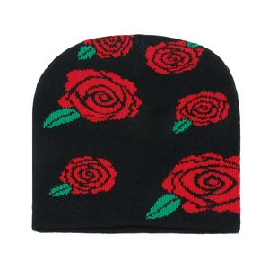 Black knit beanie hat featuring red rose jacquard pattern on a white background