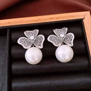Detail shot of vintage silver earrings with hollow clover patterns and hanging pearls