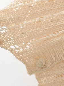 Detail of beige hollow knit mesh cardigan featuring a matching fabric-covered button