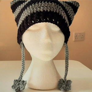 Detail of hand-knitted cat ear beanie featuring striped pattern and long tassels