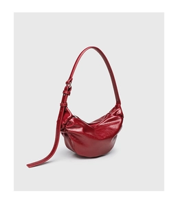 Detail of burgundy glossy pleated leather shoulder bag with adjustable buckle strap