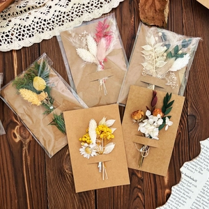 Flat lay of handmade dried flower greeting cards on vintage wood with lace decor