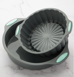 Detailed view of grey silicone cake pans with turquoise handles on marble background