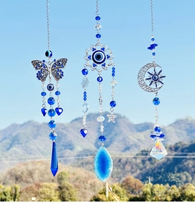 Outdoor hanging blue crystal butterfly suncatchers reflecting sunlight against blue sky