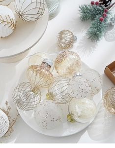 Detailed close-up of white and gold Christmas ornaments with glitter and onion shape