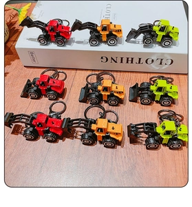 Detailed top view of alloy construction vehicle keychains in red orange and green colors