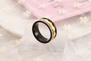 Close-up of black and gold titanium ring with micro diamonds on acrylic stand