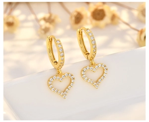 Close-up of gold-plated heart pendant earrings with sparkling pavé zircon detailing