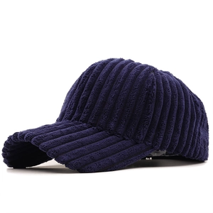 Side view of dark blue corduroy baseball cap showing thick ribbed fabric texture