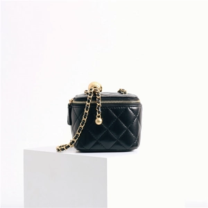 Detail of black quilted leather mini vanity case with golden ball chain strap