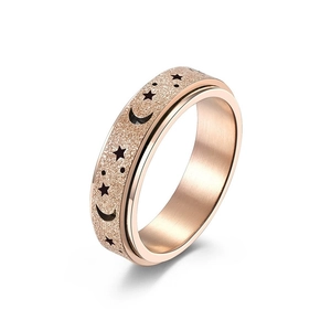Rose gold spinner ring with matte star and moon cutout pattern for stress relief