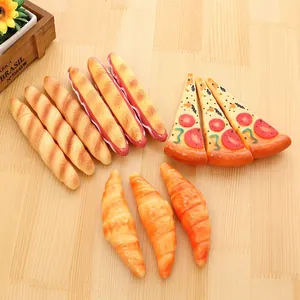 Creative food-shaped pens including pizza, baguette and croissant models on a wood desk
