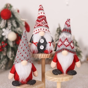 Three Christmas gnomes with knitted hats and plush beards on wooden stands for decor