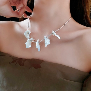 Dettaglio di una collana d'argento con accenti in madreperla su una modella