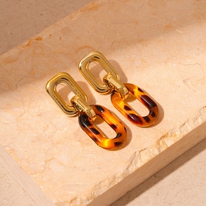 Detailed shot of vintage amber acrylic oval earrings on a marble stone slab