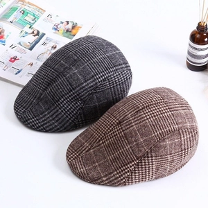 Detail of plaid ivy caps in grey and brown with breathable fabric texture and classic patterns