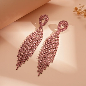 Close-up of elegant pink long tassel earrings with sparkling rhinestones and teardrop studs