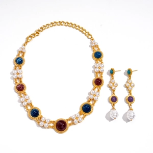 Vintage gold necklace set with pearls and colorful resin gemstones on white background