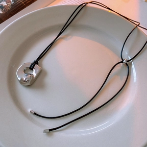 Detail of the irregular silver pendant necklace with an adjustable black wax cord