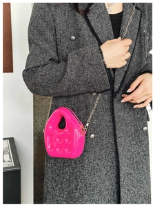 Close-up of bright pink mini PVC jelly bag with metallic gold chain and glossy 3D texture