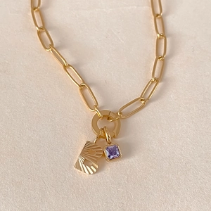 Dettaglio della collana a catena dorata con zircone viola e ciondolo lettera B