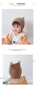 Detail view of coffee brown knitted baby bonnet with soft dual pom-pom decorations