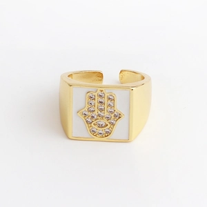 Macro detail of Hamsa hand ring featuring white enamel, zircon pavé, and evil eye symbol