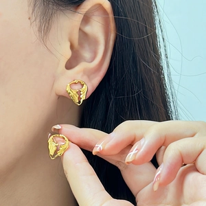 Close-up of 18K gold-plated irregular hollow heart wing earrings on model