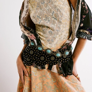 Detail of bohemian black belt with bronze medallions, studs and turquoise gemstones
