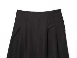 Dettaglio gonna a pieghe a vita alta con cerniera laterale nascosta e tessuto twill