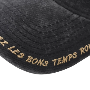 Close-up of golden embroidery and stitch texture on washed cotton baseball cap brim