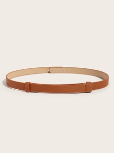 Close-up of brown synthetic leather belt with fine cross pattern texture and silver buckle