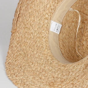 Detail shot of the 100% natural raffia straw weave with internal sweatband and tag