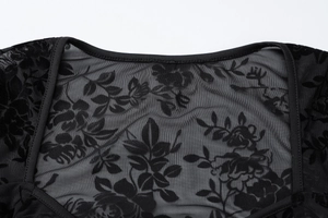 Détail de l'encolure en maille noire avec motifs floraux floqués en dentelle sophistiqués